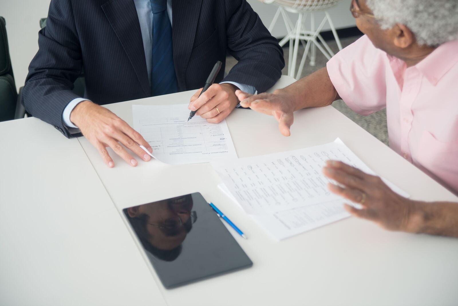 Une gestionnaire au telephone devant son poste, le dossier de souscription d'un client ouvert a l'ecran.